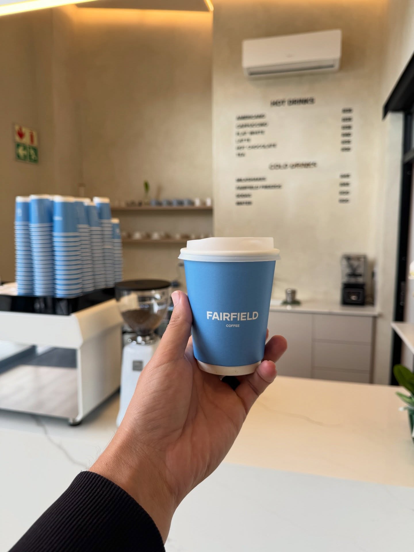 Takeaway coffee cup branded with the Fairfield Coffee logo