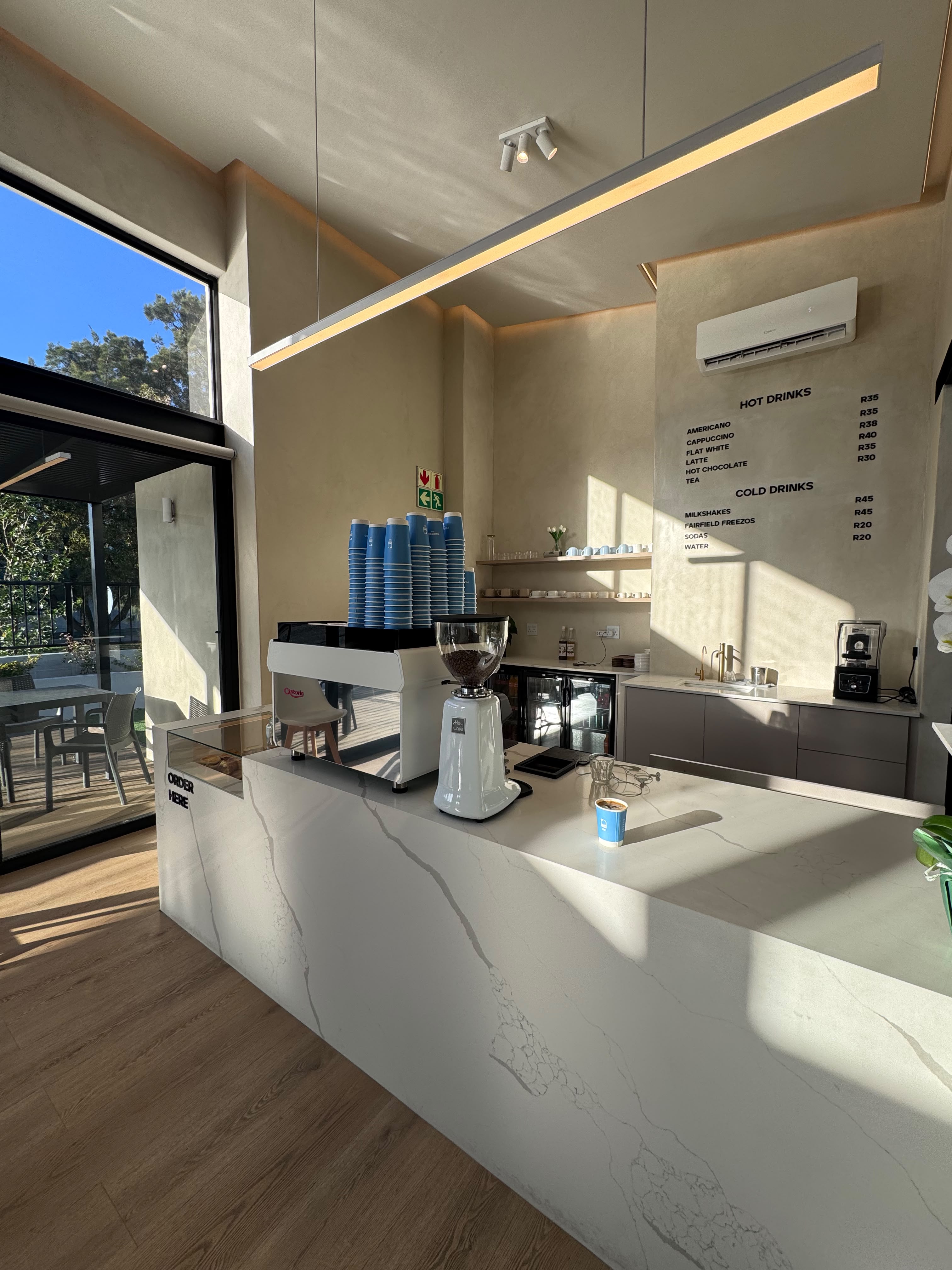Fairfield Coffee order counter with espresso machine and menu wall