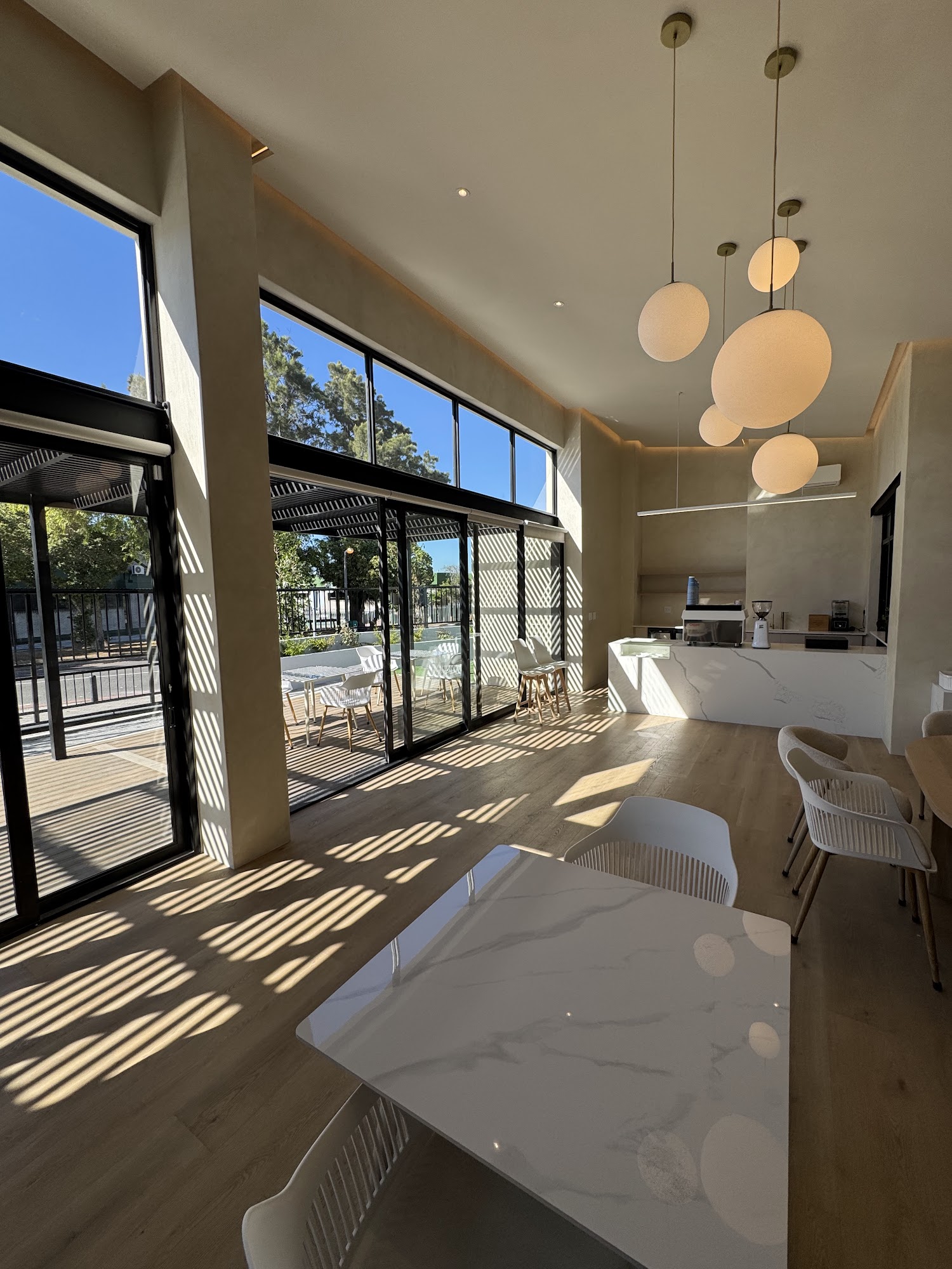 Bright, airy interior of Fairfield Coffee with tall windows and pendant lighting over the coffee bar